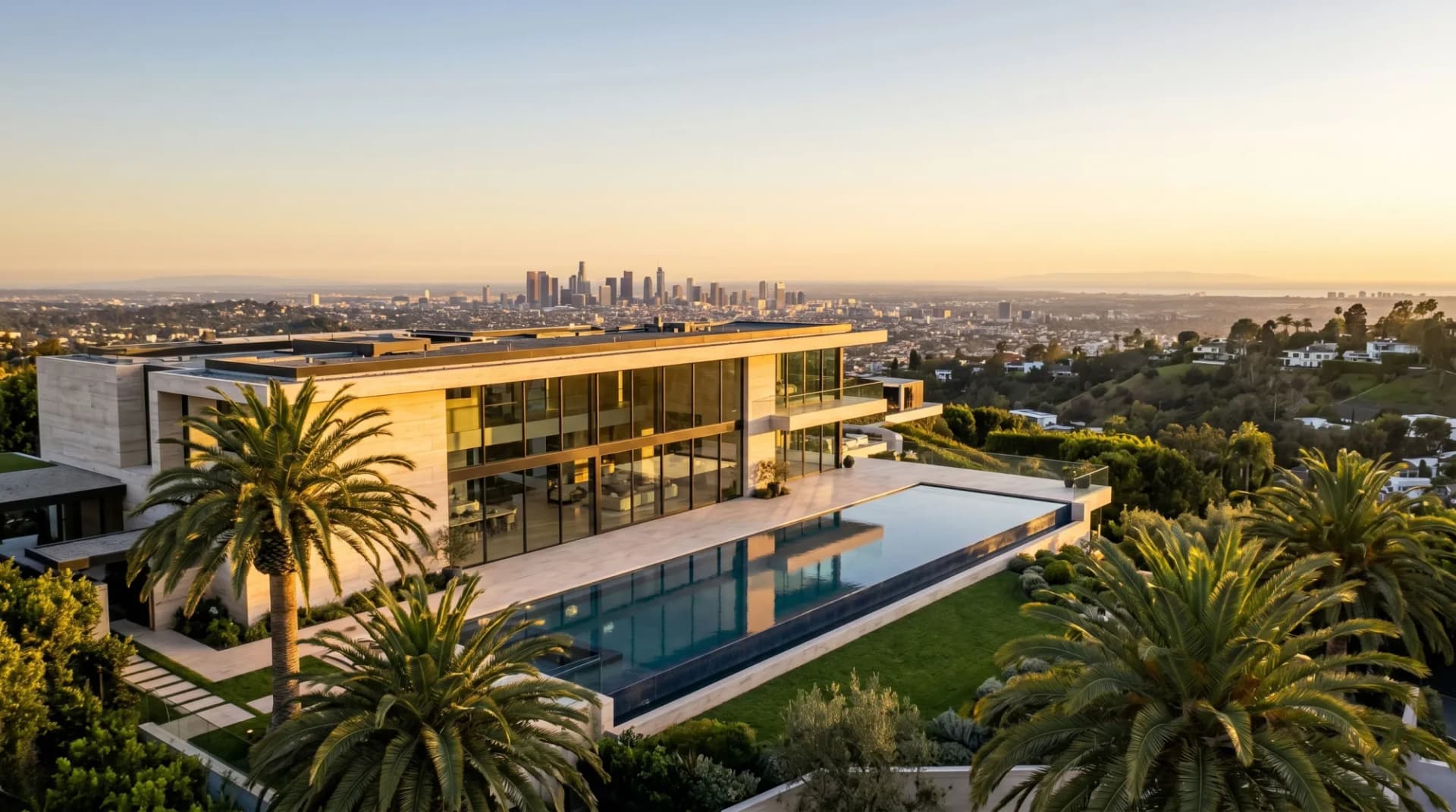 Ultra-luxury Los Angeles estate at golden hour, perched on a Bel Air hillside with sweeping views over the city to the Pacific — the architectural language of the Platinum Triangle.